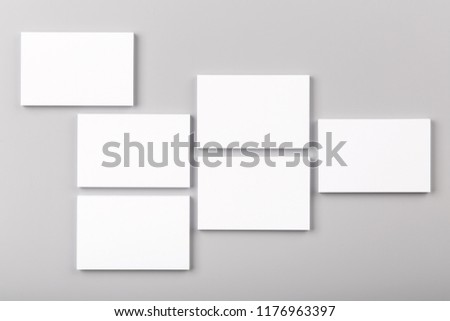 Photo of white business cards isolated on gray background. For graphic designers presentations and portfolios. Business Card isolated on gray. White business card mock-up. 