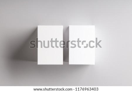 Photo of white business cards isolated on gray background. For graphic designers presentations and portfolios. Business Card isolated on gray. White business card mock-up. 