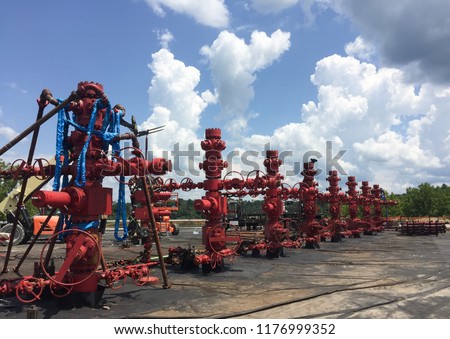 Bright Red Frac Stack at Hydraulic Fracturing Site Against Big Blue Sky Royalty-Free Stock Photo #1176999352