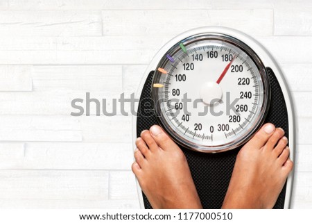 Female legs on scales on background Royalty-Free Stock Photo #1177000510