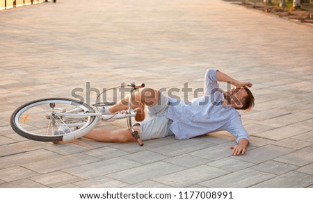 Man fallen off his bicycle on street