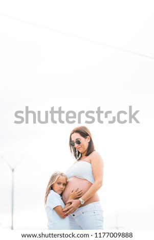 Little Girl with her pregnant mother in the field