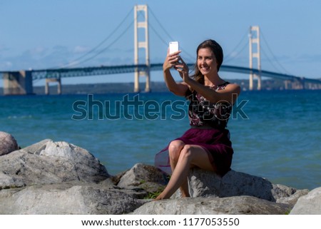 Traveller on road trip vacation taking scenic selfie picture by marina blue ocean water
