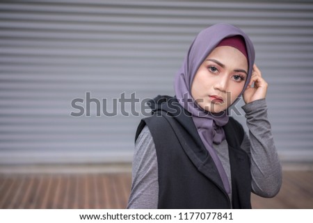 Portrait of a beautiful Asian woman wearing a hijab and casual outfit in a real environment. Muslim female hijab fashion concept.