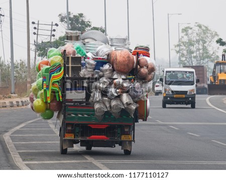 Overloaded commercial vehicle carrying household goods on a main highway south of Mysore, India. Excessive loads are commonplace on South Asian roads Royalty-Free Stock Photo #1177110127