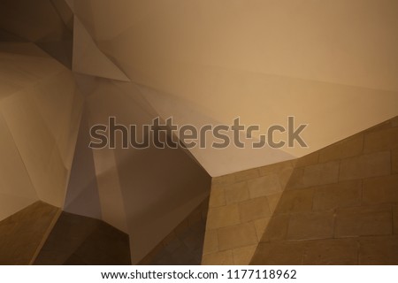 Abstract indoor view of polygonal shapes. Geometric design of a building ceiling with a group of brown lighted surfaces. Pattern of lines and angles. Architectural image.
