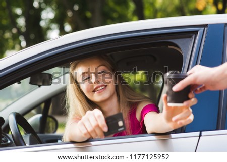 Woman inside vehicle buy drink take away. Girl driver pay card for coffee to go