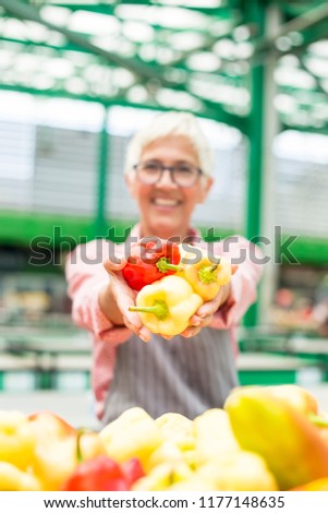 Portrait of senior woman sells organic vegetable on market