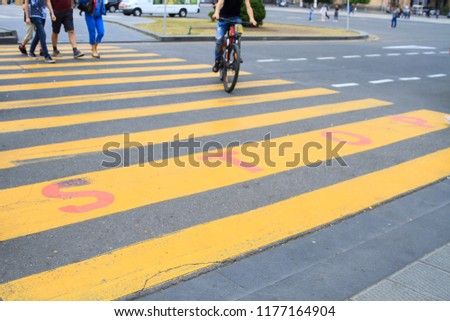 Pedestrian crossing on the road with yellow stripes.