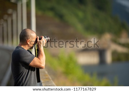 Photographer with professional camera taking pictures outdoor