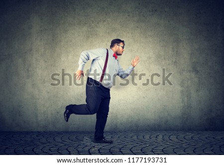 Side view of chubby businessman in formal outfit running forward being late on gray background Royalty-Free Stock Photo #1177193731
