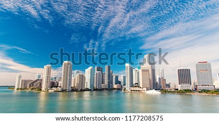 Aerial view of Miami skyscrapers with blue cloudy sky,white boat sailing next to Miami downtown