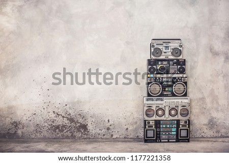 Retro old school design ghetto blaster boombox  stereo radio cassette tape recorders tower from circa 1980s front concrete wall background. Vintage style filtered photo Royalty-Free Stock Photo #1177221358