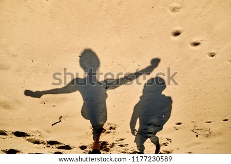 shadows of jumping girls on the sand silhouette