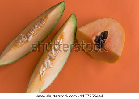 Papaya and melon on orange background. Healthy organic fruit is a perfect snack full of vitamins and antioxidants for a healthy lifestyle