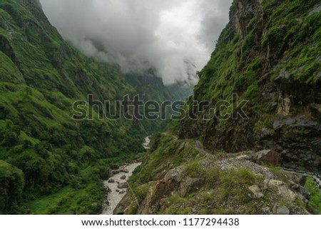 Heavy clouds in the jungle foothills of Nepal's mountains Royalty-Free Stock Photo #1177294438