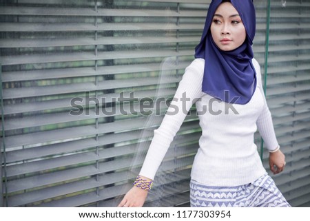 Portrait of a beautiful Asian woman wearing a hijab and casual outfit in a real environment. Muslim female hijab fashion concept.