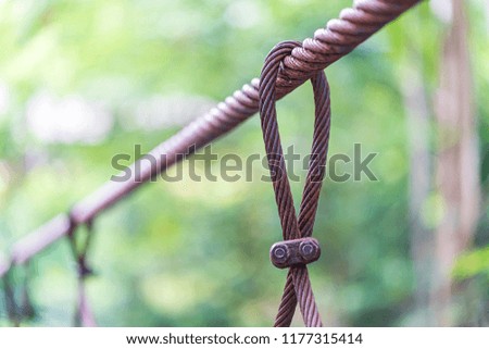 Steel wire rope lifeline on the bridge, Steel wire rope sling clip and has a large anchor suspension bridge with blurry background.