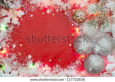 Christmas lights border with baubles and snow on red background