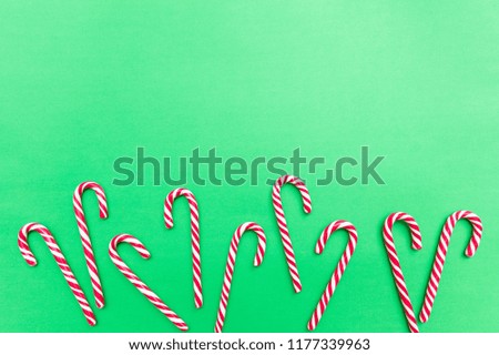 Christmas time. Candy canes on green background, copy space