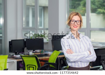 Portrait smiling woman in glasses. Portrait of business woman. Crossed arms.
