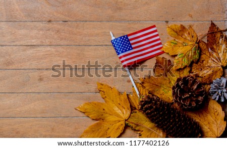 little flag of USA with maple leaves on wooden table. Above view