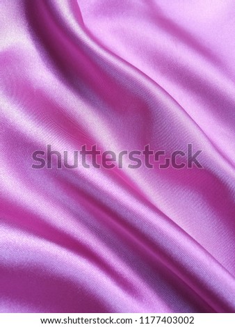 Background of wrinkled pink satin fabric texture.