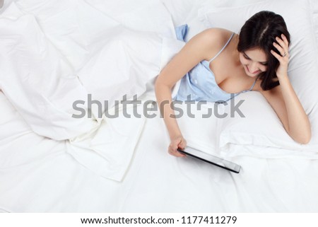 gorgeous woman using tablet computer on bed at home