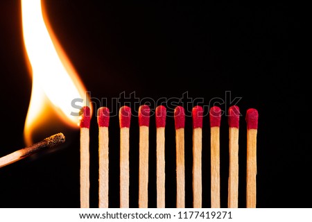 Lit match next to a row of unlit matches. The Passion of One Ignites New Ideas, Change in Others. Royalty-Free Stock Photo #1177419271