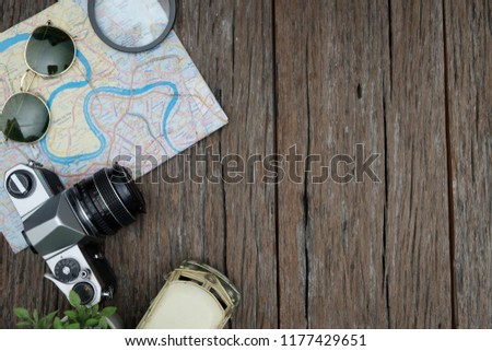 top view travel concept with retro camera films, glasses and othet items on wooden background.