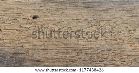 The surface of the old wood is uneven and rough with a wooden texture.