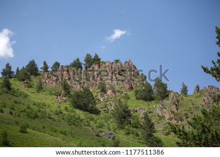 Photo of mountain slopes with vegetation and cloudy sky