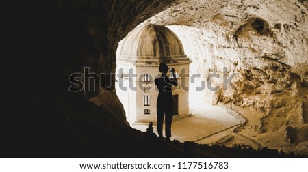 Young female takes a picture in the cave