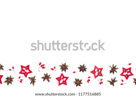 Christmas frame with red berries, anise stars and red wooden stars on white background.
