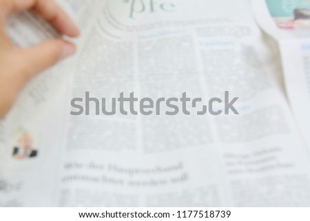 Blurred newpaper with finger 