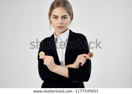  A business woman in a suit holds in her hands two coins of crypto currency                        