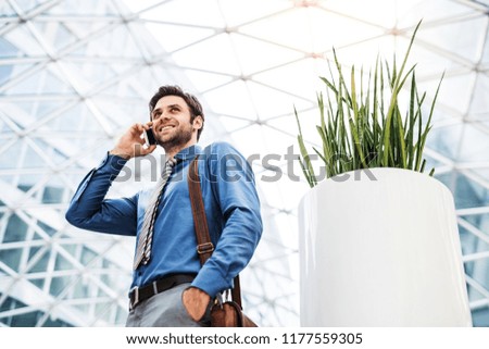 A young businessman with smartphone, making a phone call. Copy space.