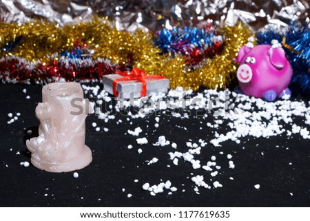 Funny congratulations happy new year, candle, pig, snow, gift, on a black background.
