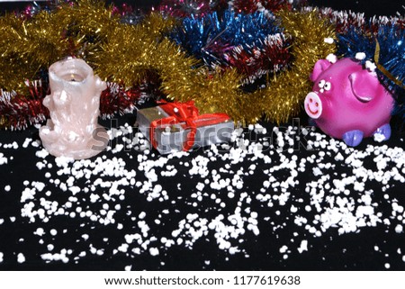 Funny congratulations happy new year, candle, pig, snow, gift, on a black background.