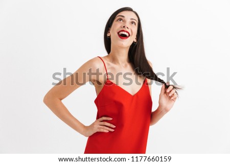 Portrait of a happy young woman in dress isolated over white background, posing while standing