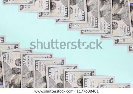 Row of a US dollar bills of a new design lies on a light blue background