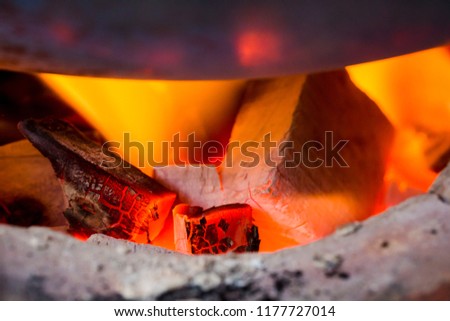 Fire on charcoal in stove with round pan for food grilling or cooking. Nature hot energy.
