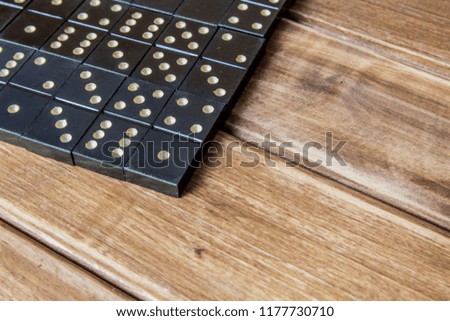 Black old, vintage dominoes on a wooden table closure. The concept of the game dominoes. Selective focus