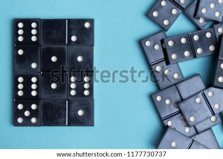 The concept of order and chaos. Chaotic disorganized dominoes and ordered dominoes on colored cardboard background