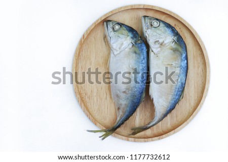 Closeup top view of raw mackerel fish on wooden plate, isolated on white background