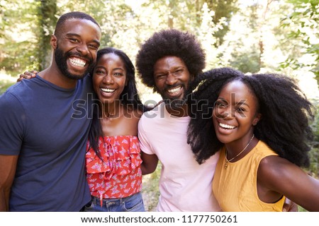Portrait of four black adult friends on a walk in the forest Royalty-Free Stock Photo #1177750261