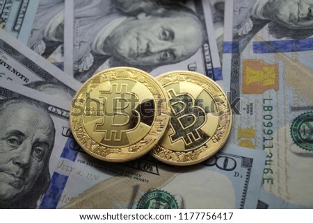 Two symbolic coins of bitcoin on banknotes of one hundred dollars. Exchange bitcoin cash for a dollar.Bitcoin cryptocurrency on US dollars. New Virtual money. Blockchain technology, mining concept.