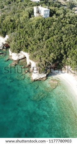 Aerial drone photo of popular mediterranean sandy beach with rocky volcanic seascape, caves and turquoise sea