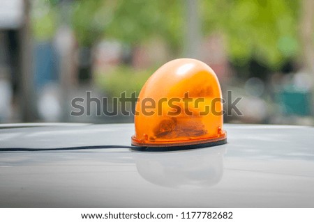 Orange flashing and revolving light on the roof of car
