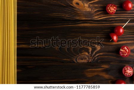 Cherry tomatoes and spaghetti on wooden background - Copy space food concept